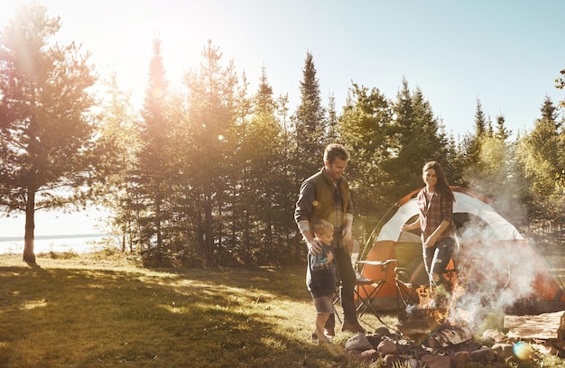A family setting up a tent at a designated campsite in Great Smoky Mountains National Park, surrounded by lush forest and clear skies.