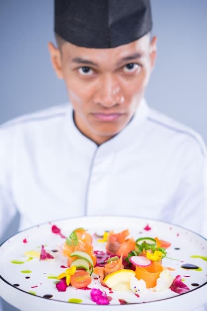 A chef in a pristine white uniform carefully plating a brightly colored, intricately arranged gourmet dish in a modern kitchen with stainless steel surfaces and vibrant fresh produce in the background, signifying culinary innovation and precision.