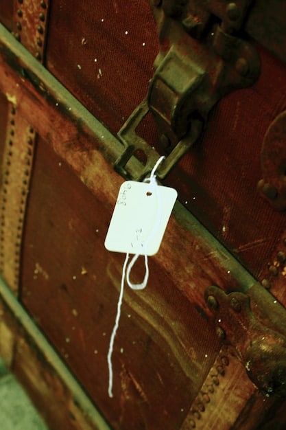 A close-up of a damaged or mislabeled baggage tag, highlighting issues in airline luggage handling, possibly on a conveyor belt.
