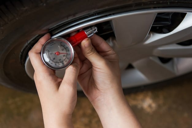 A person's hand holding a tire pressure gauge and checking the tire pressure on a car wheel, with neatly organized tools in the background.