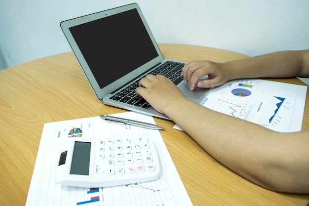 An image displaying a person using a laptop and a calculator to create a budget for a road trip. The scene includes travel brochures, maps, and sticky notes with budget items like 