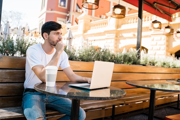 A solo traveler sitting at a coffee shop in Portland, Oregon, working on a laptop and enjoying a cup of coffee. The coffee shop has a cozy atmosphere and is filled with other patrons. Solo Traveler's Guide to the US: Safety Tips and Destination Ideas for 2025
