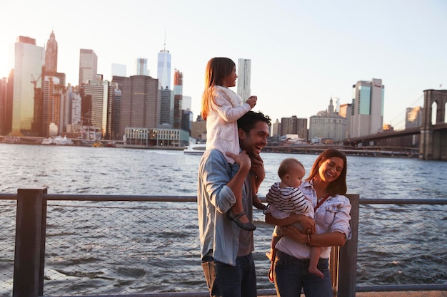 A family joyfully posing in front of the iconic Chicago skyline, with the Chicago River in the foreground, illustrating the urban adventures possible with Family Travel in the US: A Guide to Kid-Friendly Destinations in 2025.