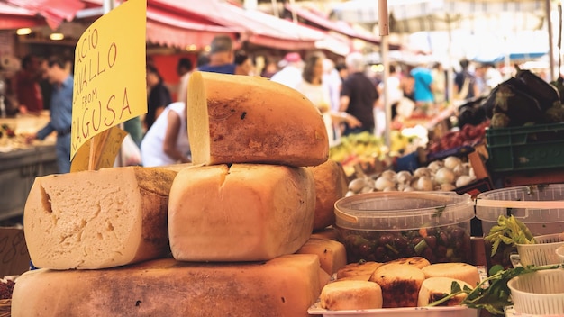 A vibrant farmers market scene, with vendors selling organic produce, artisanal cheeses, and freshly baked bread. Shoppers are seen interacting with vendors and selecting local goods. The image promotes sustainable and ethical eating, as highlighted in The US Travel Guide for Foodies: Discovering Culinary Delights in 2025.