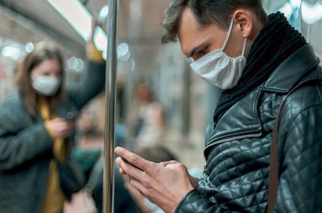 A close-up of a traveler's hands sanitizing after touching a railing in a crowded subway station.  The image conveys the importance of hygiene while traveling. It represents the section 