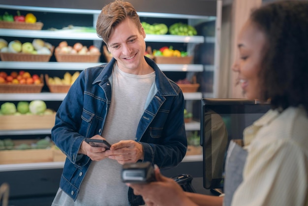 A person using a credit card at the checkout of an online grocery store displayed on a laptop, with a focus on the credit card reader and the laptop screen. Text overlay: Maximize Rewards on Online Groceries.