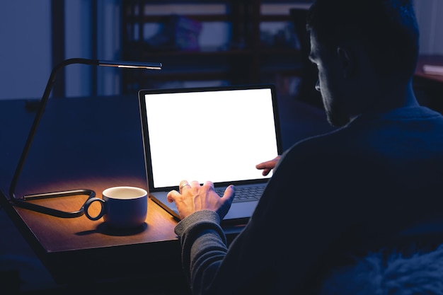 A person sitting at a desk, illuminated by the glow of a laptop screen displaying airline ticket prices and graphs. They appear to be analyzing the data carefully, suggesting research and strategic planning related to 'How to Master Airline Negotiation Tactics: A 3-Day Intensive Course for Savvy Travelers in 2025'.