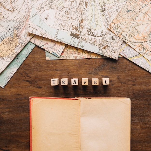 A close-up shot of a world map with various cities marked with pushpins. The map is old and weathered, suggesting a long history of travel and exploration. A pen and notebook are lying nearby.